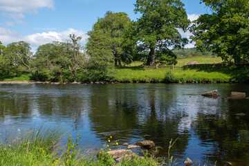 Obraz na płótnie Canvas A sunny summer's day, with blue skies over River North Tyne at Chesters in Northumberland, UK