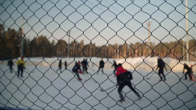Children play bandy on the hockey rink. An exciting game with passion. Slow motion.