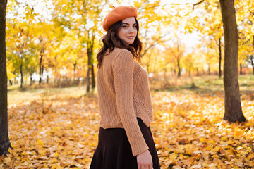 Outdoor portrait of young beautiful woman in autumn park. Warm autumn concept.