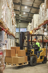 Vertical background image of forklift truck carrying boxes in warehouse interior © Seventyfour