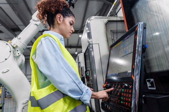 Young engineer operating machinery in factory