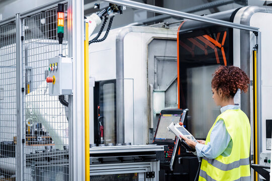 Engineer with equipment operating machine in industry