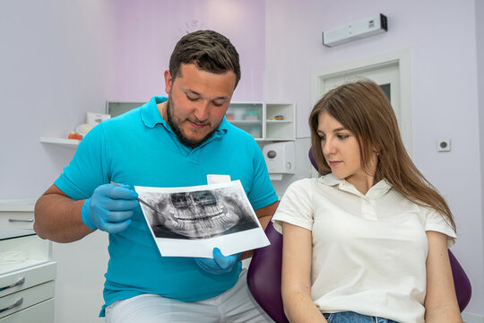 dentist doctor shows a picture of the jaw of a young patient.