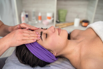 Obraz na płótnie Canvas female beautician doing facial massage her female client in a beauty clinic