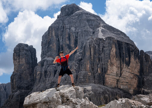 Man with arm raised standing at Cima Pisciadu, Dolomites, Italy