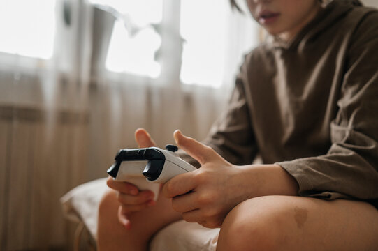 Boy sitting on bed with controller at home