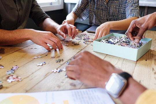 Business colleagues playing puzzle at desk in office