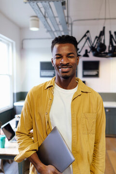 Smiling Businessman Wearing Yellow Shirt Standing At Office