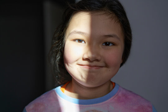 Smiling Girl With Sunlight On Face At Home