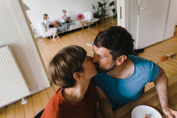 Mature romantic couple kissing each other at home