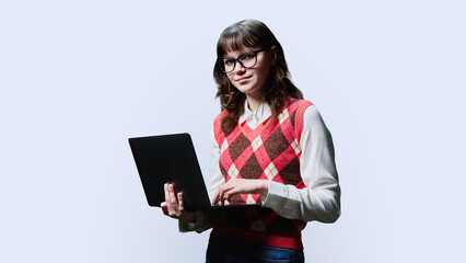 Smiling female student with laptop looking in camera on white studio background