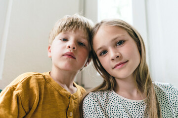 Smiling girl with brother at home