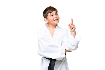 Little caucasian kid doing karate over isolated chroma key background pointing up a great idea © luismolinero