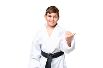 Little caucasian kid doing karate over isolated chroma key background inviting to come with hand. Happy that you came © luismolinero