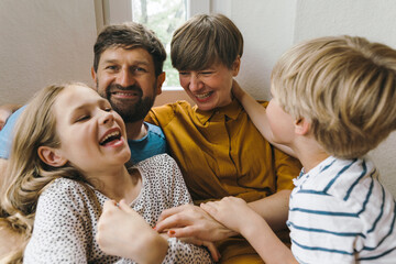 Cheerful woman having fun with family at home