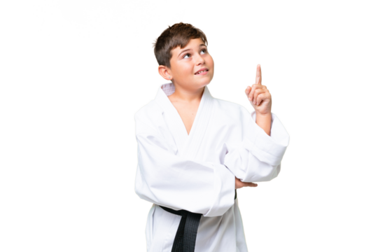 Little caucasian kid doing karate over isolated chroma key background pointing up a great idea