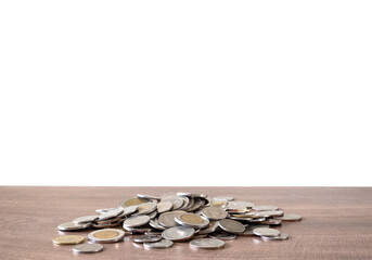 Close-up shot of stacks of coins on wooden table, white background.