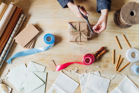 Woman cutting string with scissors at desk