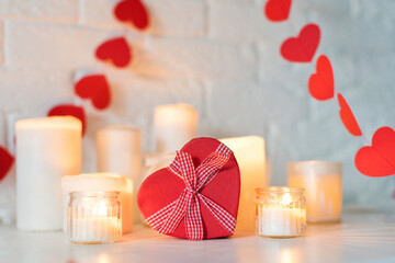 Heart shaped gift box with candles on table