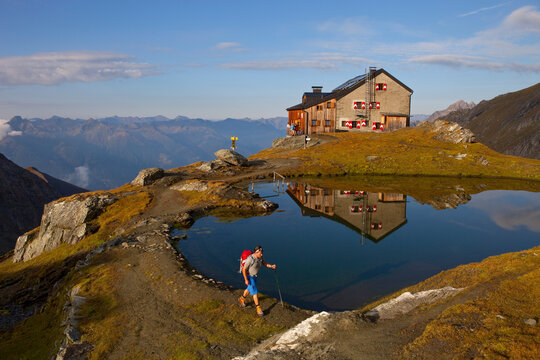 A male hiker at the lake of the Sudetendeutsche mountain hut during the Glocknerrunde, a 7 stage trekking from Kaprun to Kals around the Grossglockner, the highest mountain of Aust