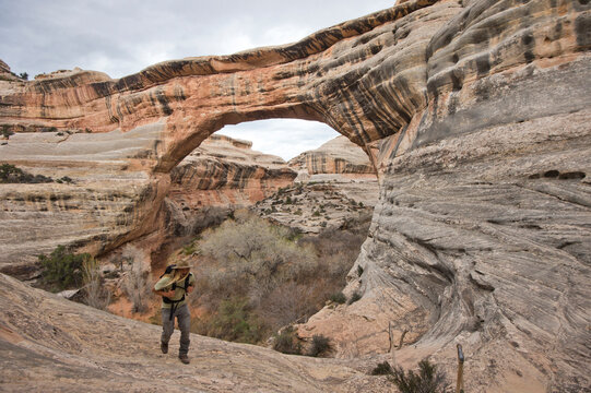 Man hiking through canyon, Natural Bridges, Utah, USA