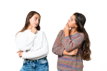 Friends girls over isolated chroma key background standing and thinking an idea