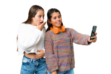 Friends girls over isolated chroma key background making a selfie with the mobile