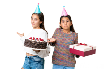 Friends girls holding gift and a birthday cake over isolated chroma key background having doubts while raising hands and shoulders