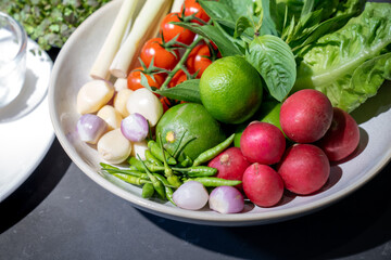 Ingredients of Spicy salad are prepared on black granite top table with various vegetable and herb.