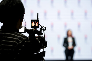 Asian man Videographer in backside are shooing and recording video in Speech event on the stage.