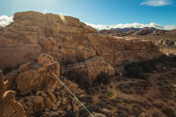 Man does trick on highline in Joshua Tree sunset.