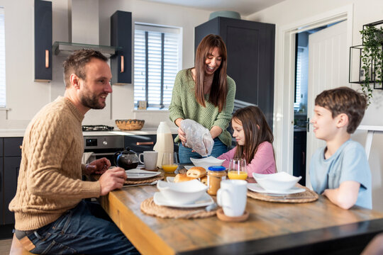 Happy family having breakfast together at table in kitchen