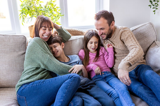 Happy man and woman spending time with children at home - Powered by Adobe