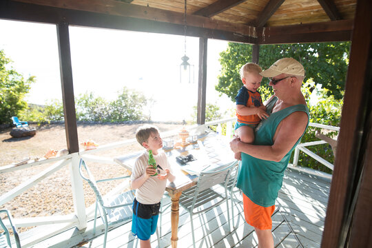 Grandfather on Caribbean Vacation with Grandsons, Talking on Porch