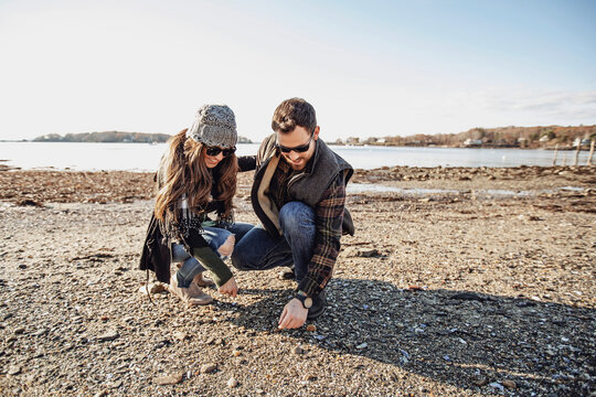 Couple looking for sea glass on beach, Peaks Island, Maine, USA