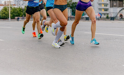 Fototapeta na wymiar legs runners athletes women and men run city marathon