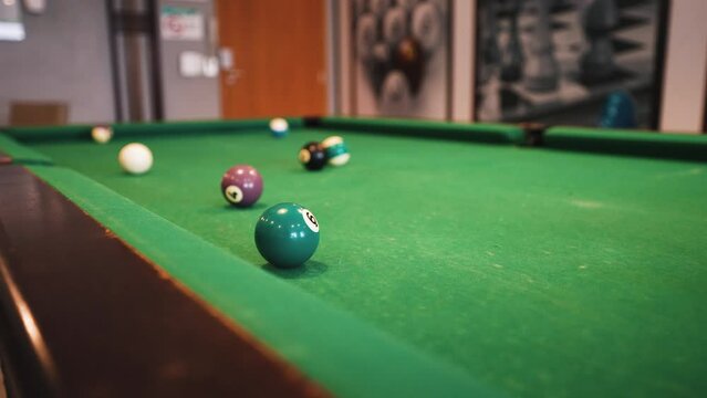 Billiard table trick shot jumping over and sinking the ball in the pocket