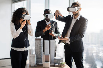 VR, business meeting conference. Multiethnic male and female business people wearing virtual reality headsets, touching air and gesturing at the office, working with new project or program.