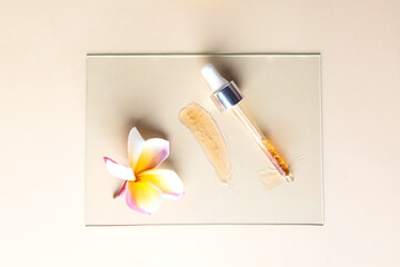 Ayurveda Spa wellness centre concept. Top view of pipette with natural oil and f exotic frangipani ...