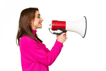 Young caucasian woman over isolated chroma key background shouting through a megaphone