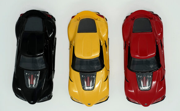 Itterbeck, Germany Feb 18 2023 Table top view on three toy cars in a row in the colors of the Belgian flag: black,  yellow, red. The cars are Toyota FT-1 concept in scale 1:32