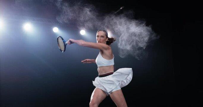 Aesthetic Shot of an Athletic Female Tennis Player with a Black Background Hitting the Ball Under Spotlights. Cinematic Super Slow Motion Captures a Winning Strong Forehand Shot with Smokey Effect 