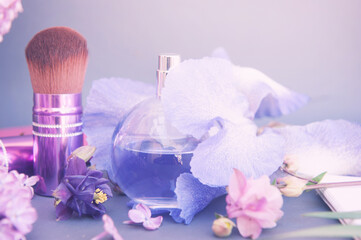 Obraz na płótnie Canvas Violet flowers, circle perfume bottle and make up brush