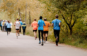 group of runners athletes running in autumn park marathon race