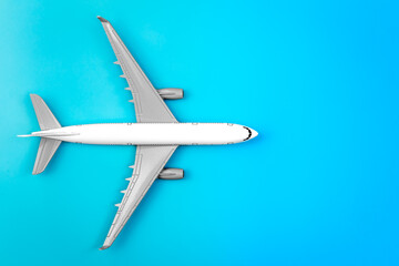 Fototapeta premium White plane, airplane on a blue background, flat lay, copy space.