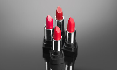 Lipstick. Fashion red Colorful Lipsticks over dark background. Red matte lipstick tints palette, Professional Makeup and beauty. Beautiful Make-up concept. Lipgloss. Lipsticks closeup