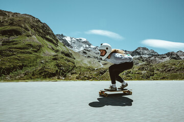 Cinematic downhill longboard session. Young woman skateboarding and making tricks between the...