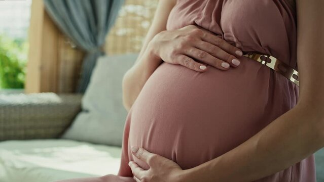 Low section of pregnant woman wearing elegance dress. Shot with RED helium camera in 8K. 