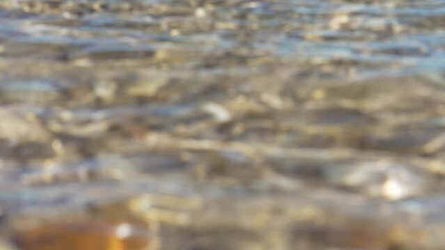 Calm defocused rippled river water surface close up. Abstract view.