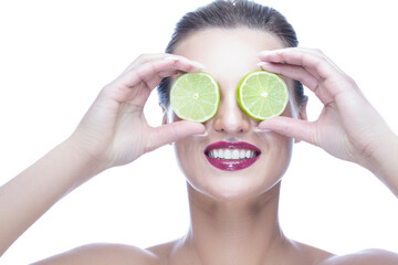 Portrait of Winsome Caucasian Woman with Perfect White Smile Posing With Green Lime Against Her Eyes On White Background